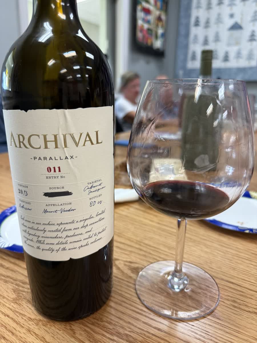 A bottle of Parallax, Entry No. 011, poured at a table