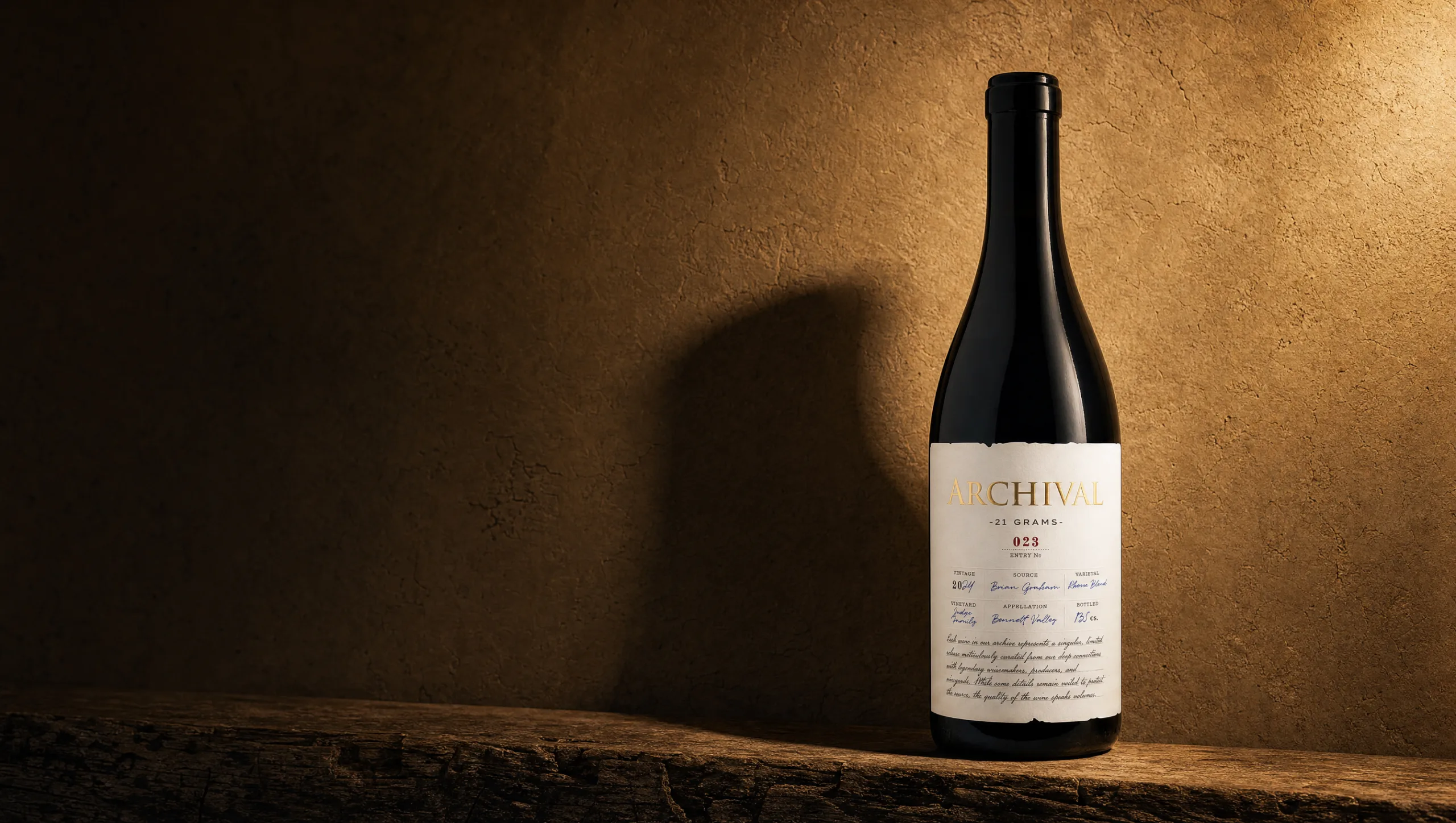A bottle of Archival 21 Grams, Entry No. 023, on a rough wooden ledge against a warm plaster wall